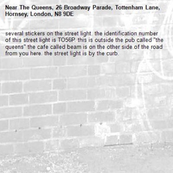 several stickers on the street light. the identification number of this street light is TO56P. this is outside the pub called &quot;the queens&quot; the cafe called beam is on the other side of the road from you here. the street light is by the curb.-The Queens, 26 Broadway Parade, Tottenham Lane, Hornsey, London, N8 9DE