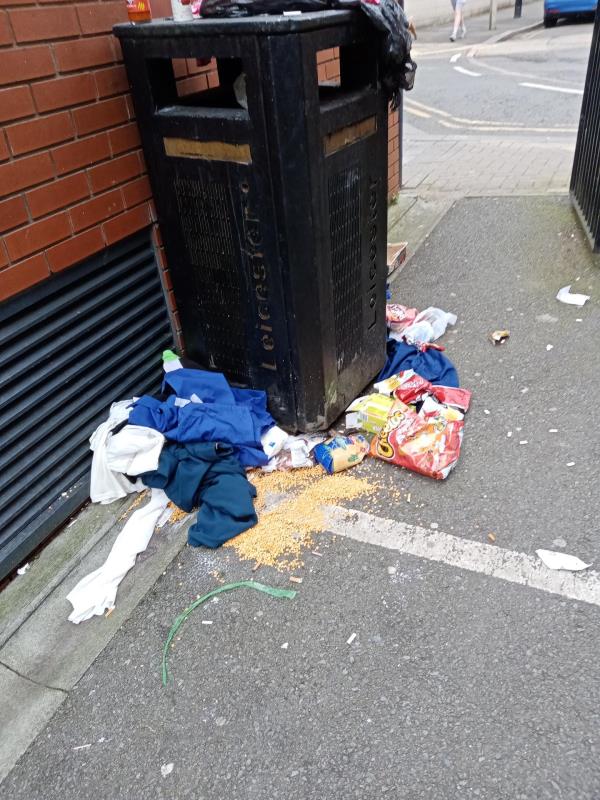 Overflowing litter bin and dumped domestic waste (food, clothing) next to 3 Colton Square-St George's Church