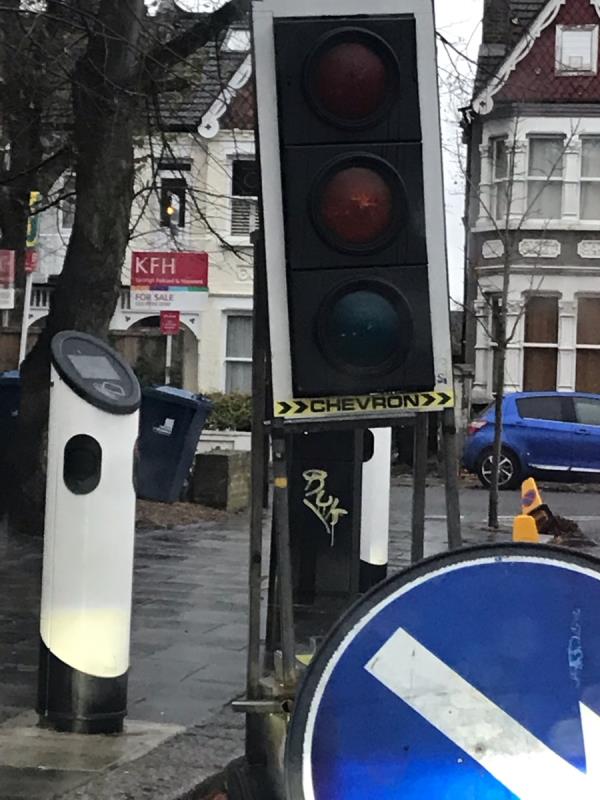 Yellow spray painted tag is located on a black cabinet at a electric charge point on Sutherland Road junction Drayton Green w13-Apex Court, 22 Sutherland Road, West Ealing, W13 0DU