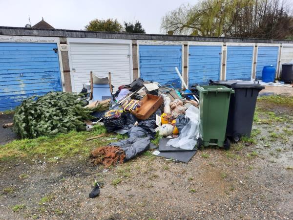 Very large amount of flytipped material at Pulborough Avenue garages . Large quantity of builders, waste, chairs, old fence panels,  bags, mixed household waste,  and a green  and black dustbins filled with contaminated waste. This is not a one man job to clear.-Little Upperton, 2 Freeman Avenue, Eastbourne, BN22 9NT