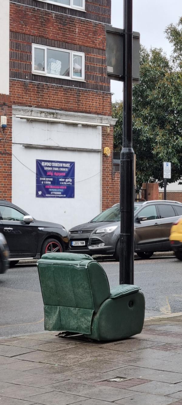 Dark green armchair left on the pavement on High Street North in Manor Park -499A, High Street North, Manor Park, London, E12 6TH