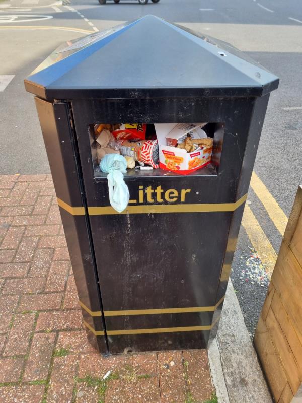 The bin outside Plaistow Library is overflowing and there is lots of rubbish around the parklet.-83 North Street, Plaistow, London, E13 9HL