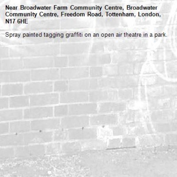 Spray painted tagging graffiti on an open air theatre in a park.-Broadwater Farm Community Centre, Broadwater Community Centre, Freedom Road, Tottenham, London, N17 6HE