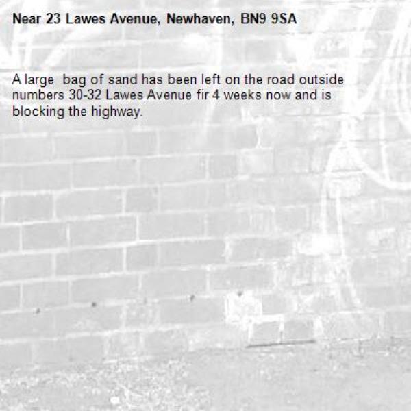 A large  bag of sand has been left on the road outside numbers 30-32 Lawes Avenue fir 4 weeks now and is blocking the highway.-23 Lawes Avenue, Newhaven, BN9 9SA