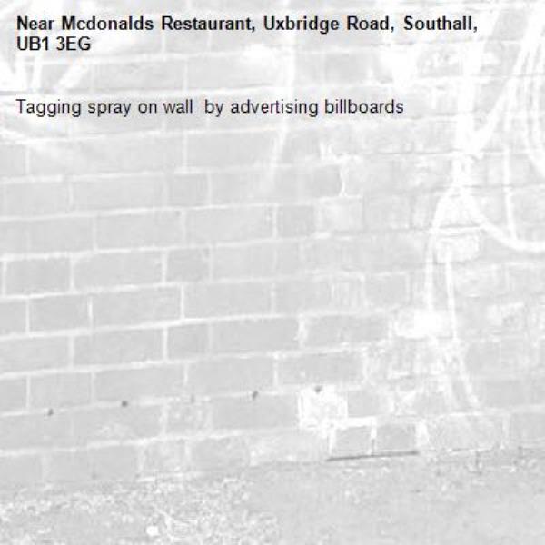 Tagging spray on wall  by advertising billboards-Mcdonalds Restaurant, Uxbridge Road, Southall, UB1 3EG