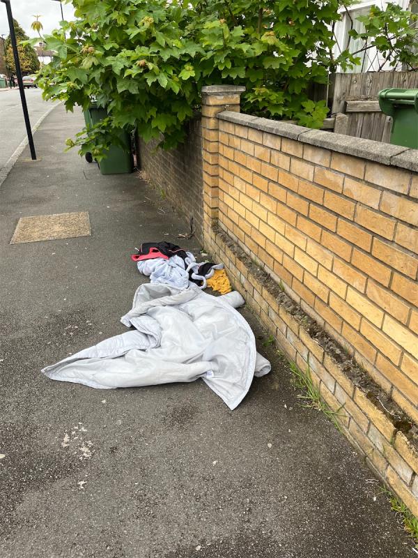 Clothes dumped on the pavement but also overgrown trees which are forcing people to the edge of the kerb to walk-45 Margery Park Road, Forest Gate, London, E7 9LD